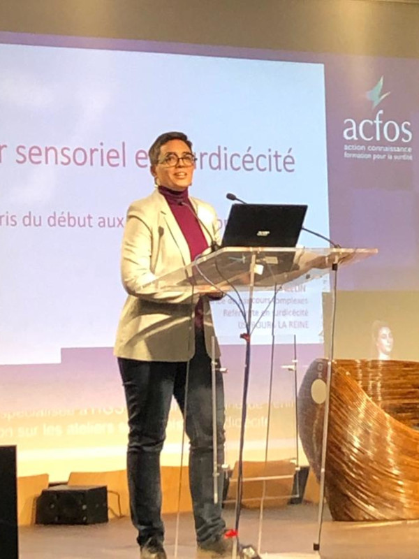 Atelier sensoriel Elodie Thiercelin sur scène avec la présentation powerpoint de son atelier sensoriel projeté derrière elle